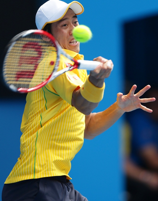 Kei Nishikori of Japan plays a forehand in his fourth round match against Rafael Nadal of Spain