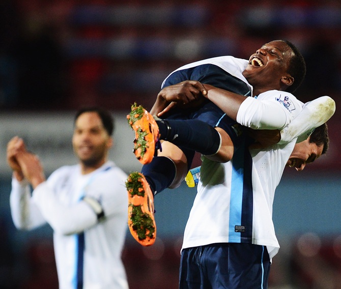 Dedryck Boyata of Manchester City lifts team mate Marcos Mesquita Lopes in celebration after victory