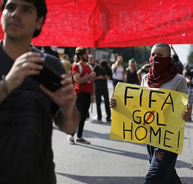 A demonstrator holds a banner during a protest against the 2014 World Cup in Sao Paulo