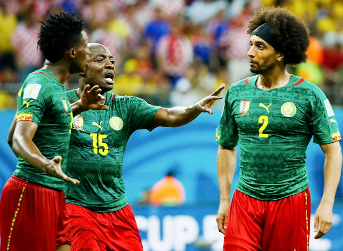 Cameroon's Achille Weboc ,centre, tries to separate teammates Benjamin Moukandjo, left, and Benoit Assou-Ekotto as they argue during their Group A match against Croatia