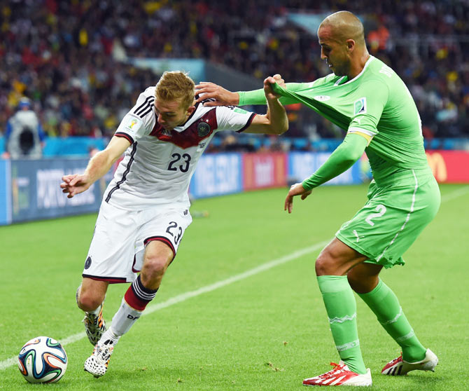 Christoph Kramer of Germany controls the ball against Madjid Bougherra of Algeria during their match on Monday