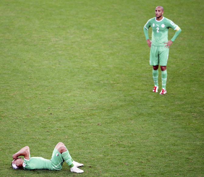 Algeria's Sofiane Feghouli and Madjid Bougherra react after their 2014 World Cup round of 16 game against Germany on Monday