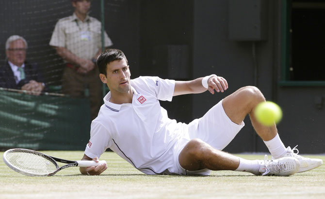 Novak Djokovic of Serbia slips during his quarter-final against Marin Cilic of Croatia at the Wimbledon