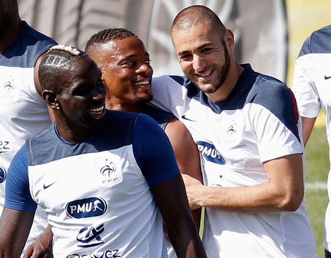 French players Mamadou Sakho (center) Patrice Evra (center) and Karim Benzema (right) interact during a training session at the Botafogo soccer club's Santa Cruz stadium