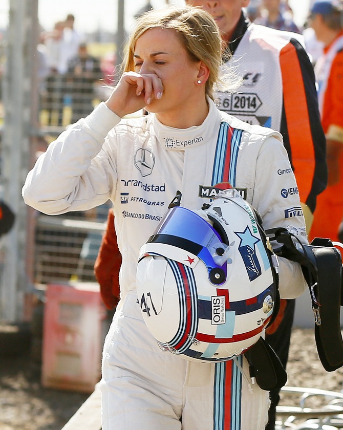 Williams Formula One driver Susie Wolff of Britain wipes her face after her car broke down