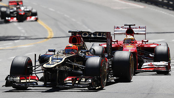 Lotus Formula One driver Kimi Raikkonen (left) steers his car ahead of Ferrari's driver Fernando Alonso