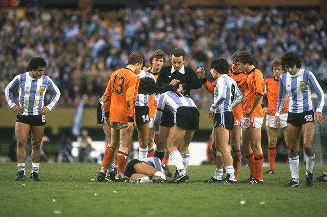 Gonella, the referee (centre) of Italy looks at his watch as an Argentinan player lies injured on the ground during the final at the Monumental Stadium in Buenos Aires