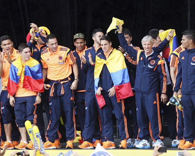 Colombia's national coach Jose Pekerman (second right) and soccer team players greet fans after arriving at Bolivar park in Bogota