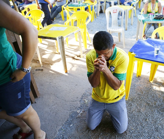 A Brazil fan prays