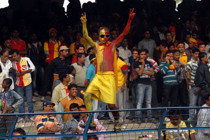An East Bengal fan enjoys the action during a derby match