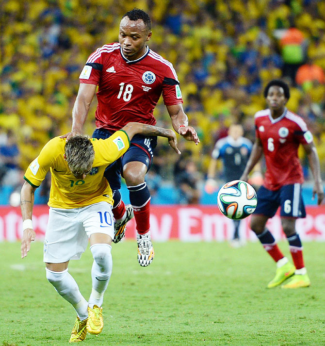 Neymar of Brazil is challenged by Juan Camilo Zuniga of Colombia during their 2014 FIFA World Cup quarter-final at Castelao in Fortaleza on July 4, 2014