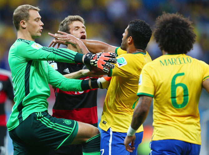 Goalkeeper Manuel Neuer of Germany separates Thomas Mueller of Germany and Hulk of Brazil after a challenge in the box during their semi-final on Tuesday