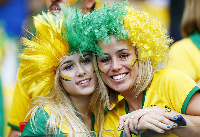 Fans of Brazil pose for pictures as they wait for the start of their 2014 World Cup semi-finals against Germany at the Mineirao stadium in Belo Horizonte on Tuesday