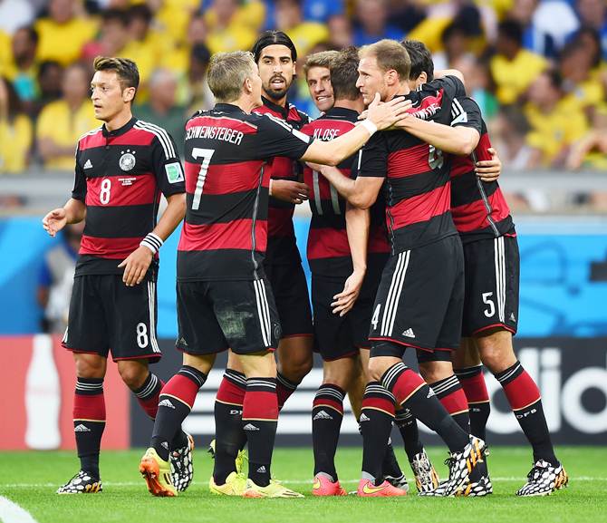 The German players celebrate with scorer Thomas Mueller after their first goal