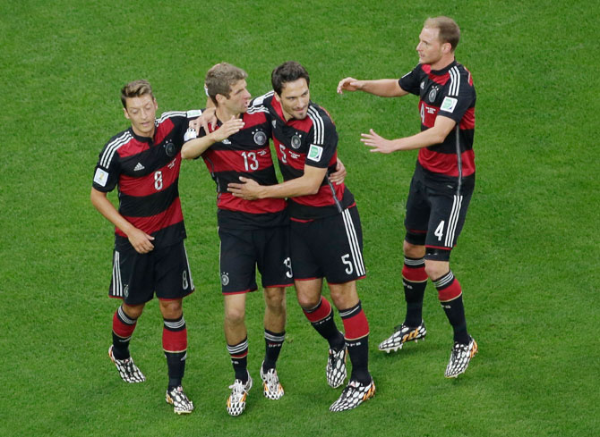Thomas Mueller of Germany celebrates scoring his team's first goal with Mats Hummels, Mesut Oezil (left) and Benedikt Hoewedes
