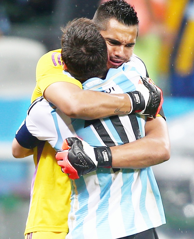 Lionel Messi and goalkeeper Sergio Romero of Argentina react after Messi's made penalty kick in a shootout
