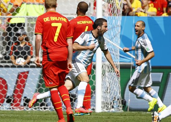 Argentina's Gonzalo Higuain runs past Belgium's Kevin De Bruyne (7) and Vincent Kompany to celebrate after scoring a goal