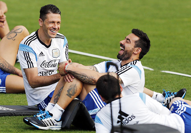 Argentina's players Martin Demichelis (left) and Ezequiel Lavezzi share a joke with Lionel Messi (right, bottom) during a training session in Vespasiano on Thursday