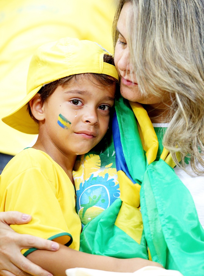 A young Brazil fan is consoled after being defeated by the Netherlands