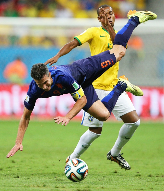 Fernandinho of Brazil challenges Robin van Persie of the Netherlands resulting in a yellow card for Fernandinho