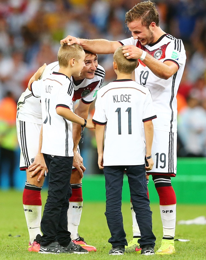 Mario Goetze, Miroslav Klose of Germany and sons celebrate after defeating Argentina 1-0 in extra time