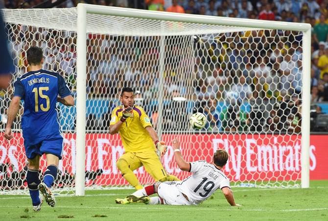 Mario Goetze of Germany slips the ball past Argentina goalkeeper Sergio Romero in the World Cup final 