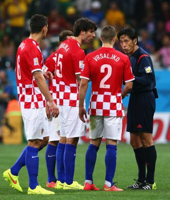 Referee Yuichi Nishimura speaks to Dejan Lovren, Vedran Corluka and Sime Vrsaljko of Croatia after awarding a penalty kick