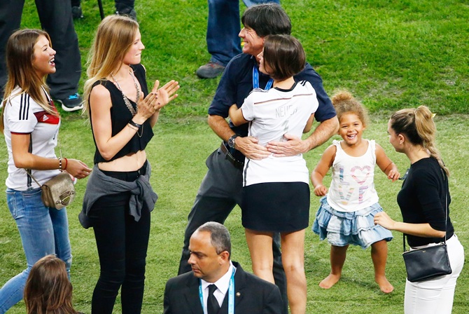 Head coach Joachim Loew of Germany hugs Kathrin Gilch, girlfriend of Manuel Neuer of   Germany, as Montana Yorke, girlfriend of Andre Schuerrle of Germany, and Sarah   Brandner, girlfriend of Bastian Schweinsteiger of Germany, look on