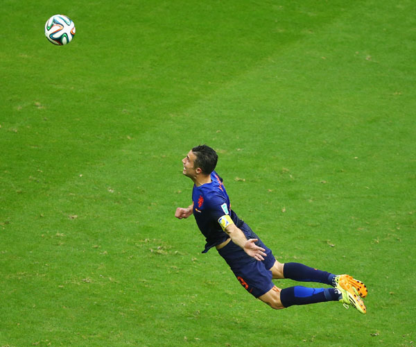 Robin van Persie of the Netherlands scores the team's first goal with a diving header against Spain in Salvador
