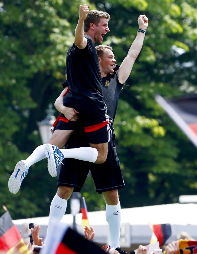Germany's goalkeeper Manuel Neuer carries Thomas Mueller