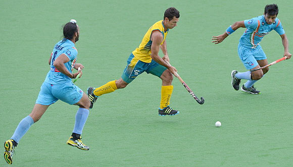 Jamie Dwyer of Australia (centre) runs between India's Manpreet Singh (left) and Sadar Singh (right)