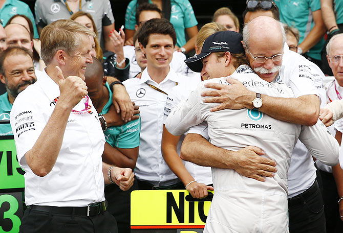 Mercedes Formula One driver Nico Rosberg of Germany embraces Daimler CEO Dieter Zetsche (right) after winning the German F1 Grand Prix at the Hockenheim racing circuit on Sunday
