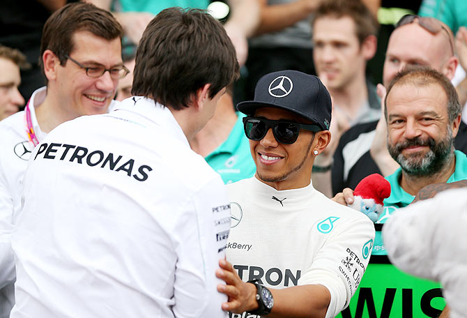 Lewis Hamilton of Great Britain and Mercedes GP smiles as he speaks with Mercedes GP Executive Director Toto Wolff after the German Grand Prix on Sunday