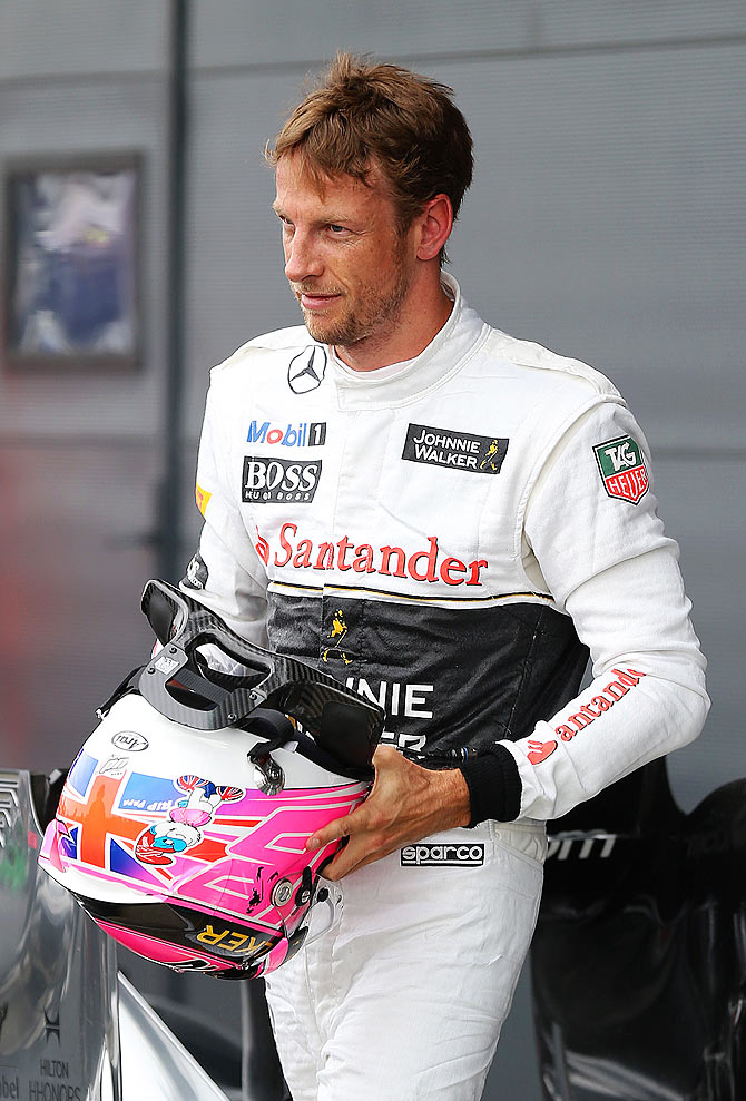 Jenson Button of Great Britain and McLaren celebrates in Parc Ferme after claiming third place on the grid