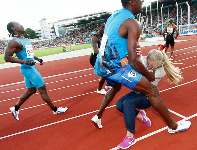 Usain Bolt collides with a flower girl after crossing the finish line