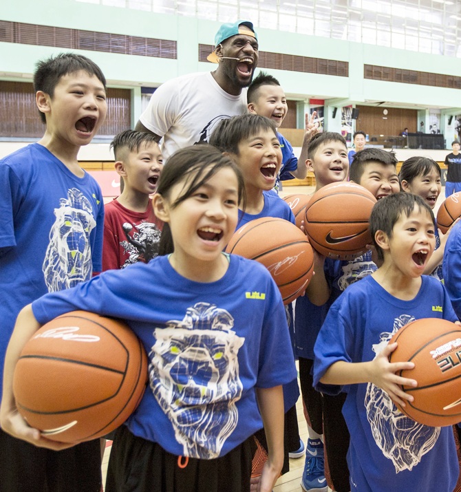 NBA basketball player LeBron James (back centre) of the Cleveland Cavaliers poses for a photo with children after a basketball clinic
