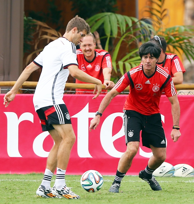 Joachim Loew, right, head coach of Germany battles for the ball with Thomas Mueller