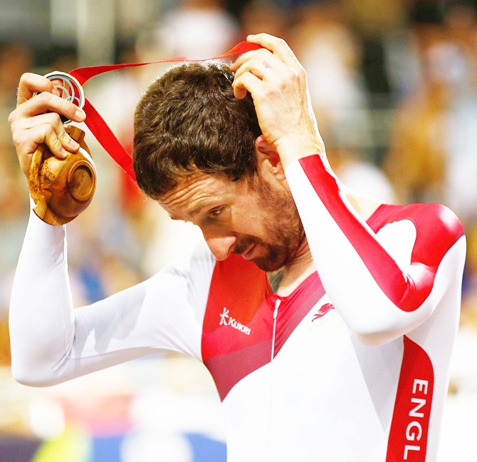 Sir Bradley Wiggins of England takes off his silver medal during the medal ceremony for   the Men's 4000 metres Team Pursuit final at Sir Chris Hoy Velodrome