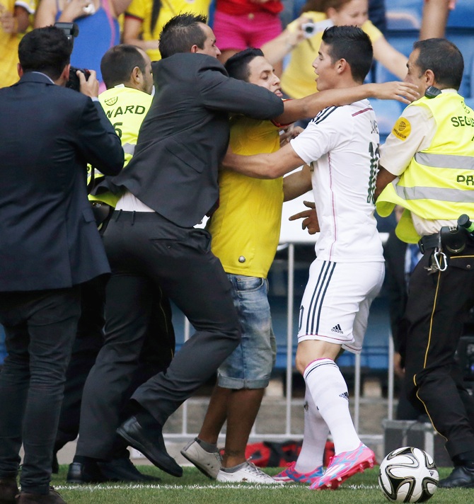 A fan tries to embrace Colombia's soccer player James Rodriguez during   his presentation at the Santiago Bernabeu stadium in Madrid