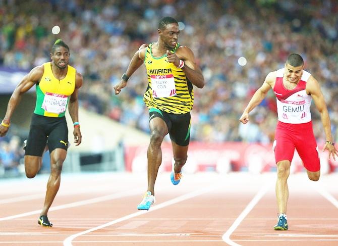 Kemar Bailey-Cole of Jamaica, centre, crosses the line to win gold ahead of silver medalist Adam Gemili of England, right, in the Men's 100 metres final at Hampden Park during day five of the Glasgow 2014 Commonwealth Games