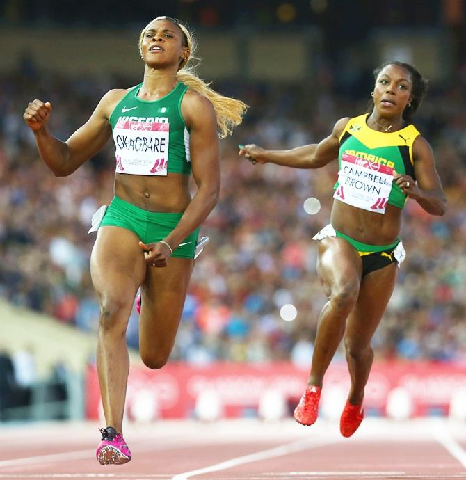 Blessing Okagbare of Nigeria, left, crosses the line to win gold ahead of silver medalist   Veronica Campbell-Brown of Jamaica in the Women's 100 metres final