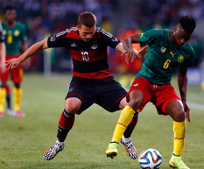 Germany's Lukas Podolski (left) challenges Cameroon's Alexandre Song 