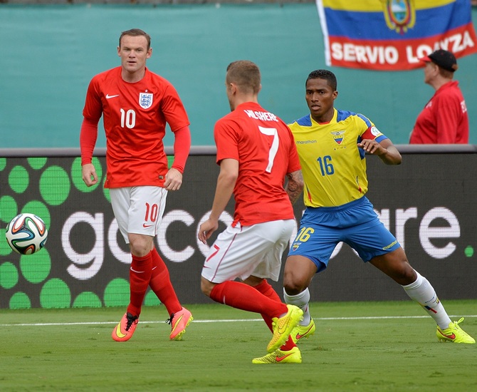 England forward Wayne Rooney,left, controls the ball as Ecuador defender Luis Antonio Valencia (right) defends the play