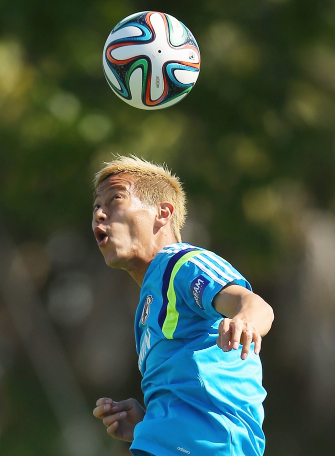 Keisuke Honda heads the ball during a Japan training session