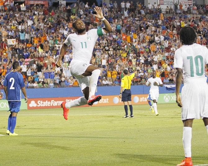 Ivory Coast's Didier Drogba,centre, leaps in the air to celebrate his goal