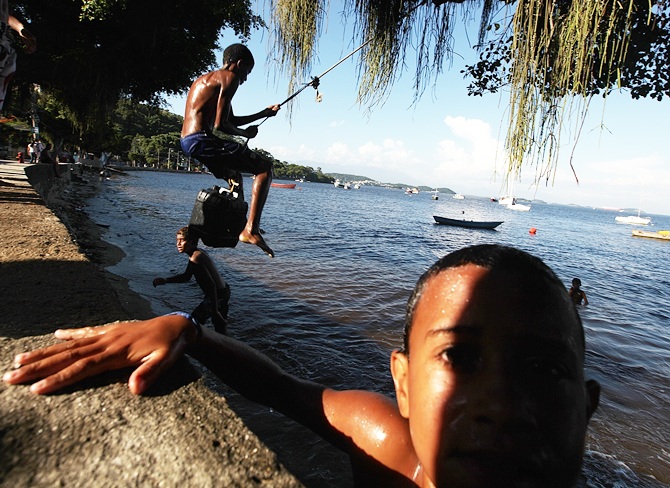 Kids play along the shoreline of the Guanabara Bay in Rio de Janeiro
