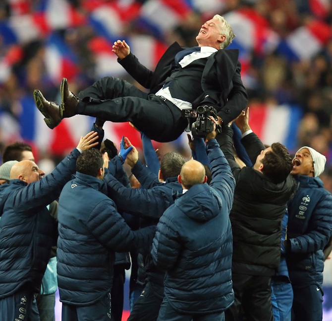 France throw their Coach Didier Deschamps in the air after winning the FIFA 2014 World Cup Qualifier Play-off