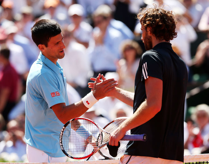 Novak Djokovic of Serbia shakes hands with Ernests Gulbis of Latvia