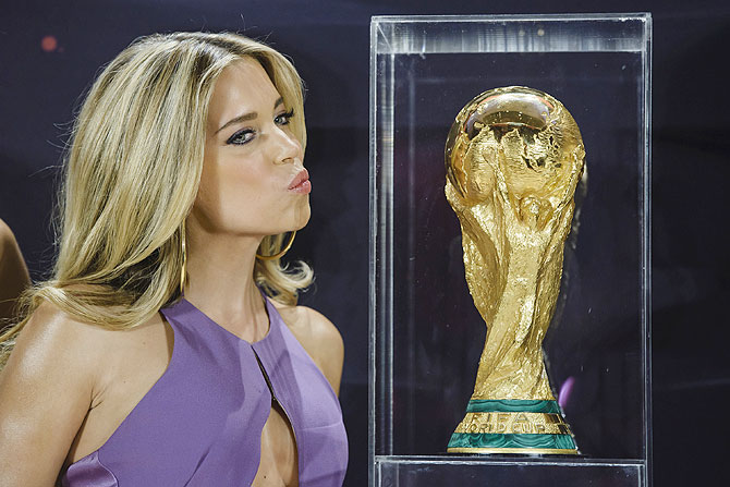 A model poses with the World Cup trophy during a photocall
