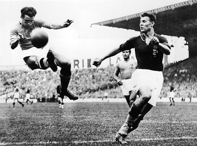 Alfredo Foni (left) of Italy tries to reach a cross during the FIFA World Cup final against Hungary in Paris on June 19, 1938.
